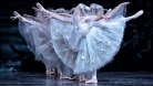 Des danseuses de ballet en costumes blancs et voilées se produisent sur scène, posant avec une jambe et les deux bras tendus, dans des directions opposées.  © Michael Slobodian