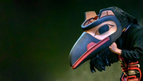 Un interprète autochtone posé de profil qui porte un masque Gitxsan de corbeau. © Dancers of Damelahamid, Raven Mother