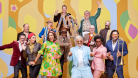 Pink Martini poses in front of funky background 