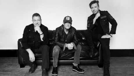 Black and white image of Glass Tiger sitting on a couch 