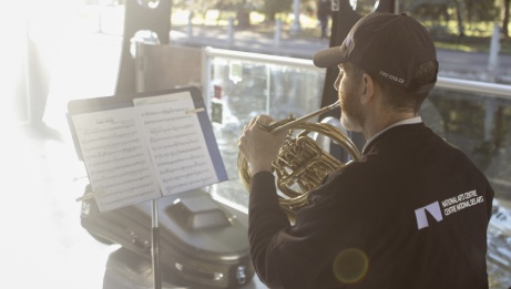 Le corniste Lawrence Vine joue de son instrument au coucher du soleil sur un bateau sur le canal Rideau. 