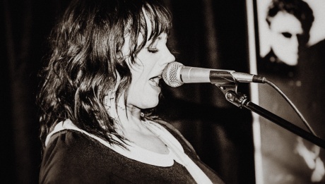 Miesha, in black and white, singing into the microphone