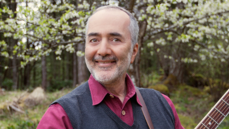 Raffi smiling and standing in the woods 