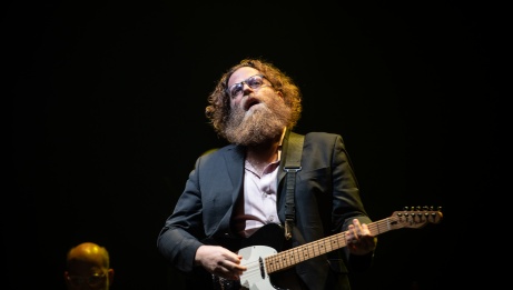 Ben Caplan on stage with a guitar