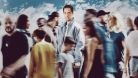 Grand Corps Malade standing in a blurry crowd 