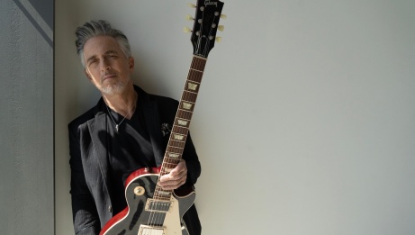 Colin James holding his guitar.