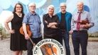 The five members of the Rideau Ramblers outside. A member is holding his guitar and another member is holding his violin. © Dawn Cameron