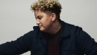 Kellie Loder is dressed in black and standing in front of a white background. © Brody White