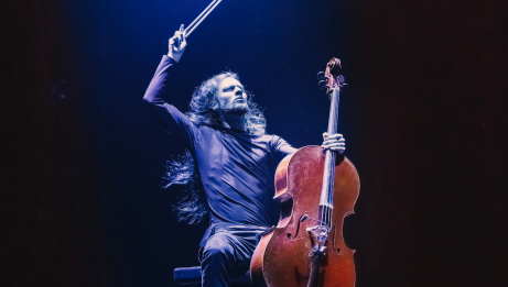 Raphael Weinroth-Browne is brandishing his bow and holding his cello.