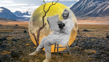 Man sitting on a chair reading a book, with a spring Nunavut landscape in the background.